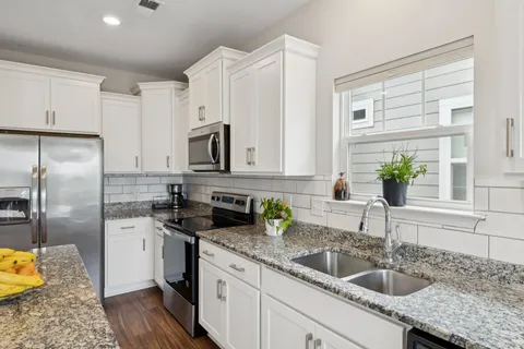 a kitchen with a sink a counter top space cabinets and stainless steel appliances