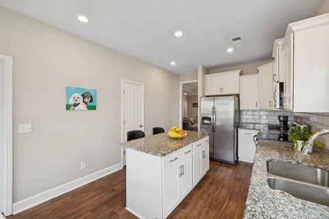 a kitchen with refrigerator cabinets and wooden floor