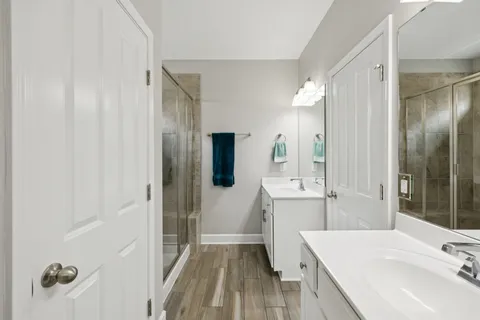 a bathroom with a sink a toilet a mirror and shower