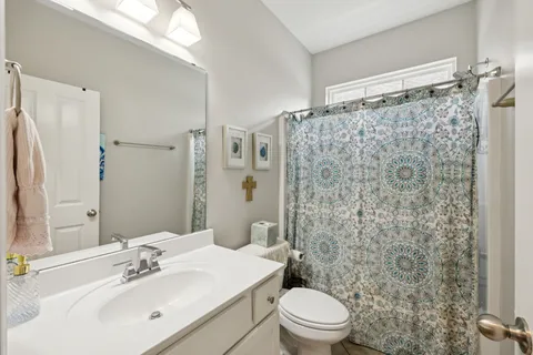 a bathroom with a shower curtain sink and toilet