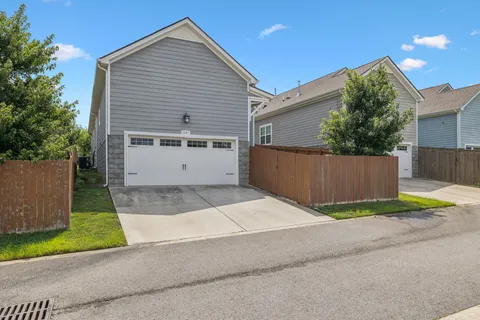 a view of backyard with small cabin and wooden fence