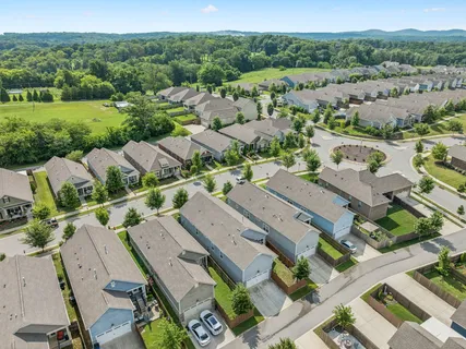 an aerial view of residential houses with outdoor space and street view