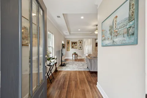 a view of a hallway with wooden floor and furniture