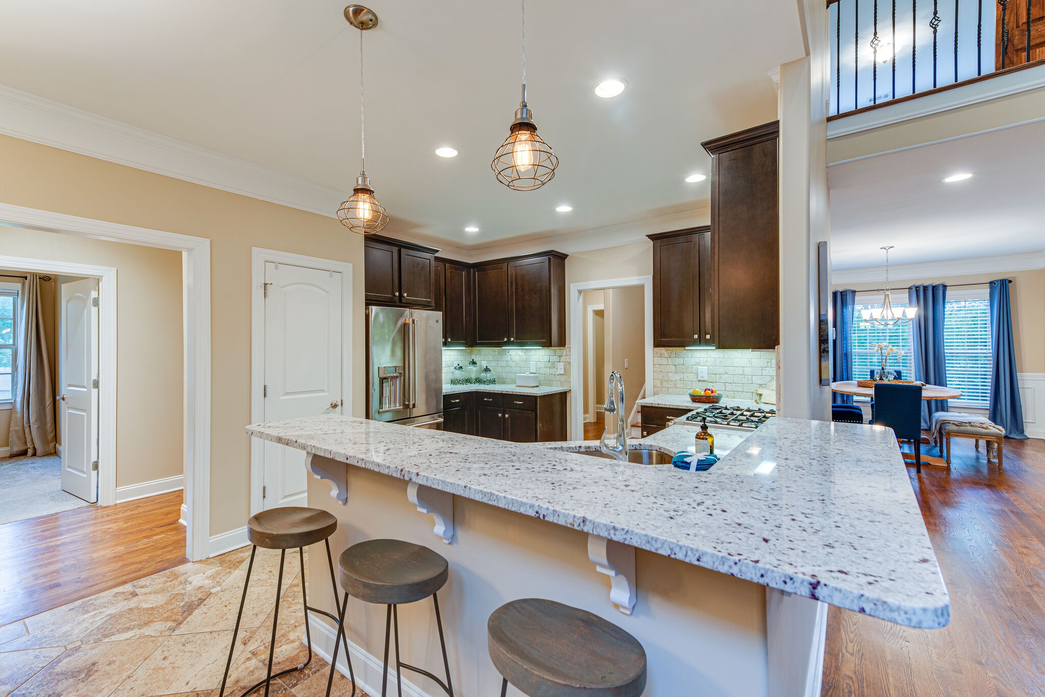 a kitchen with granite countertop kitchen island stainless steel appliances a sink and a refrigerator