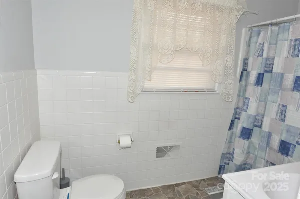 a white toilet sitting next to a shower curtain