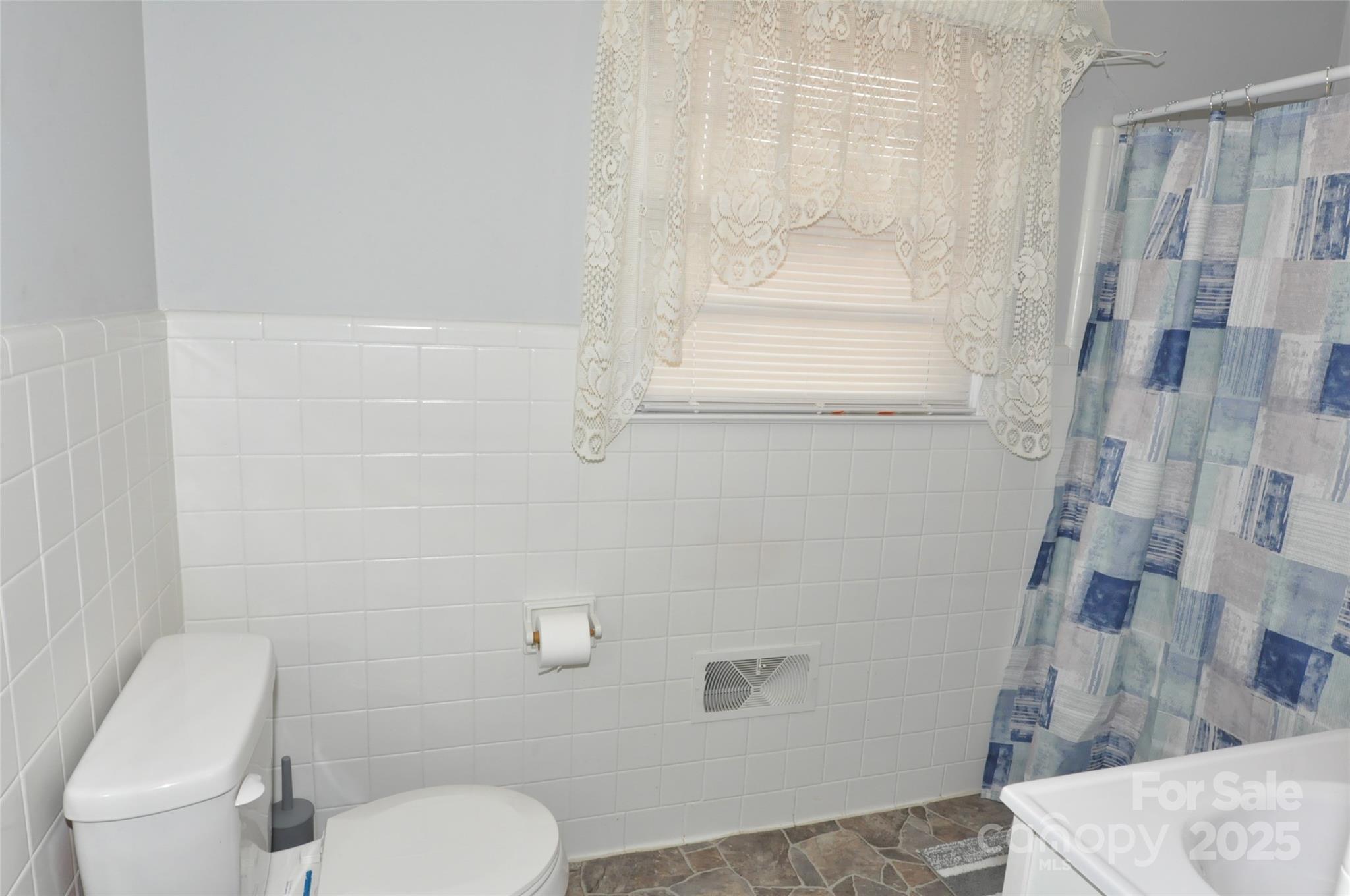 378 Center Street, Unit 1 Chester, SC 29706 - Photo 26 of 28 a white toilet sitting next to a shower curtain