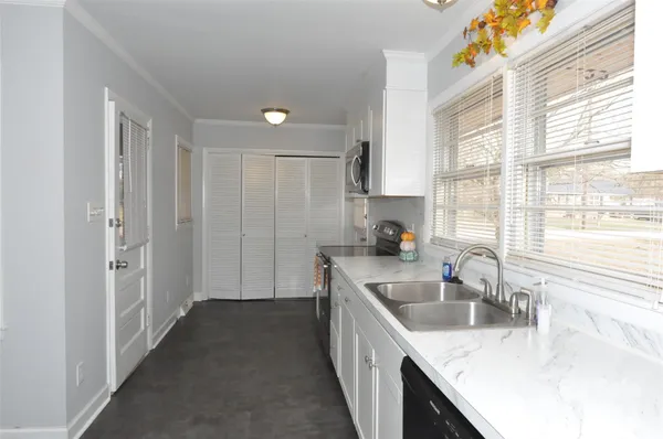a kitchen with granite countertop a sink stove and cabinets