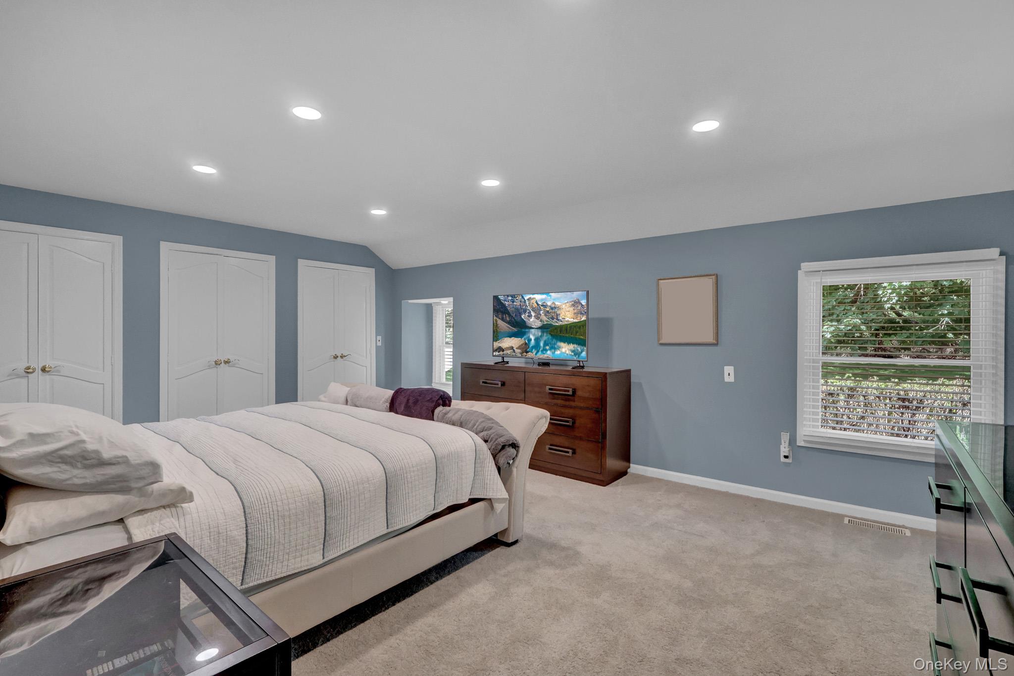 15 Stillwater Road Nissequogue, NY 11780 - Photo 18 of 43 Spacious room featuring light blue walls, recessed lighting, carpet flooring, a window with horizontal blinds, and three sets of white bi-fold closet doors