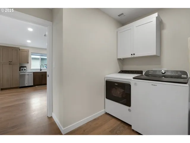 a kitchen with stainless steel appliances a stove a microwave and a hard wood floors