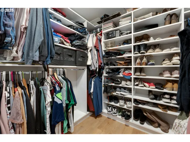 a view of walk in closet with clothes and shoes