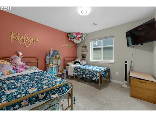 a bedroom with a bed window and a flat screen tv