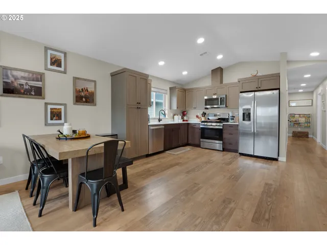 a kitchen with stainless steel appliances kitchen island granite countertop a sink and refrigerator
