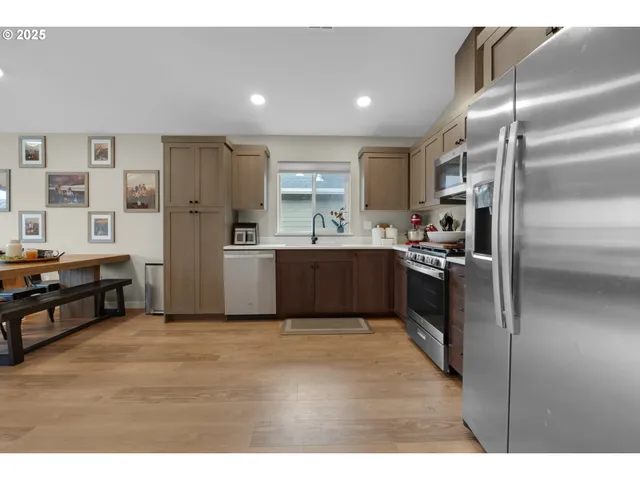 a kitchen with stainless steel appliances kitchen island granite countertop a refrigerator and a sink