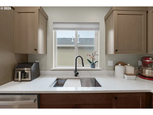 a kitchen with a sink cabinets and a window