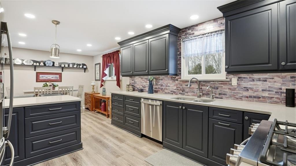 6142 Penn Drive Butler, PA 16002 - Photo 11 of 34 a kitchen with kitchen island granite countertop a sink stove and cabinets