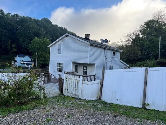 a view of backyard with barbeque grill and plants