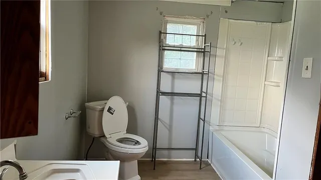 a bathroom with a toilet a sink and shower