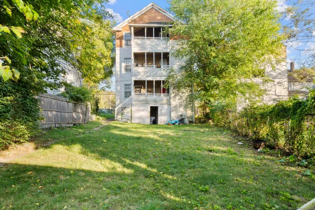a view of a big house with a big yard and large trees