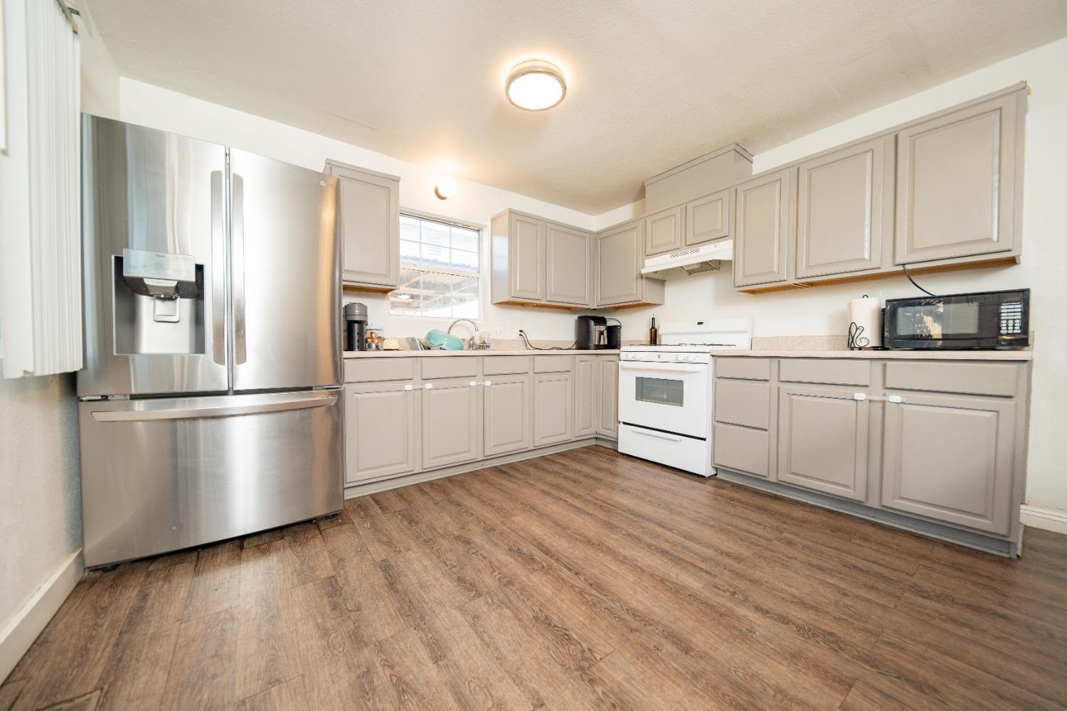 836 North E Street Tulare, CA 93274 - Photo 4 of 13 a kitchen with stainless steel appliances a refrigerator sink and cabinets