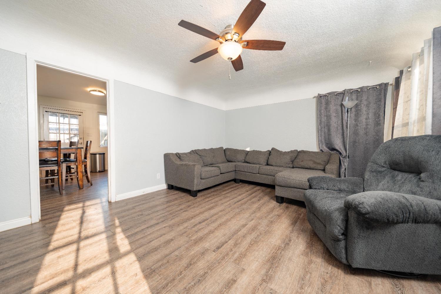 836 North E Street Tulare, CA 93274 - Photo 5 of 13 a living room with furniture and a wooden floor