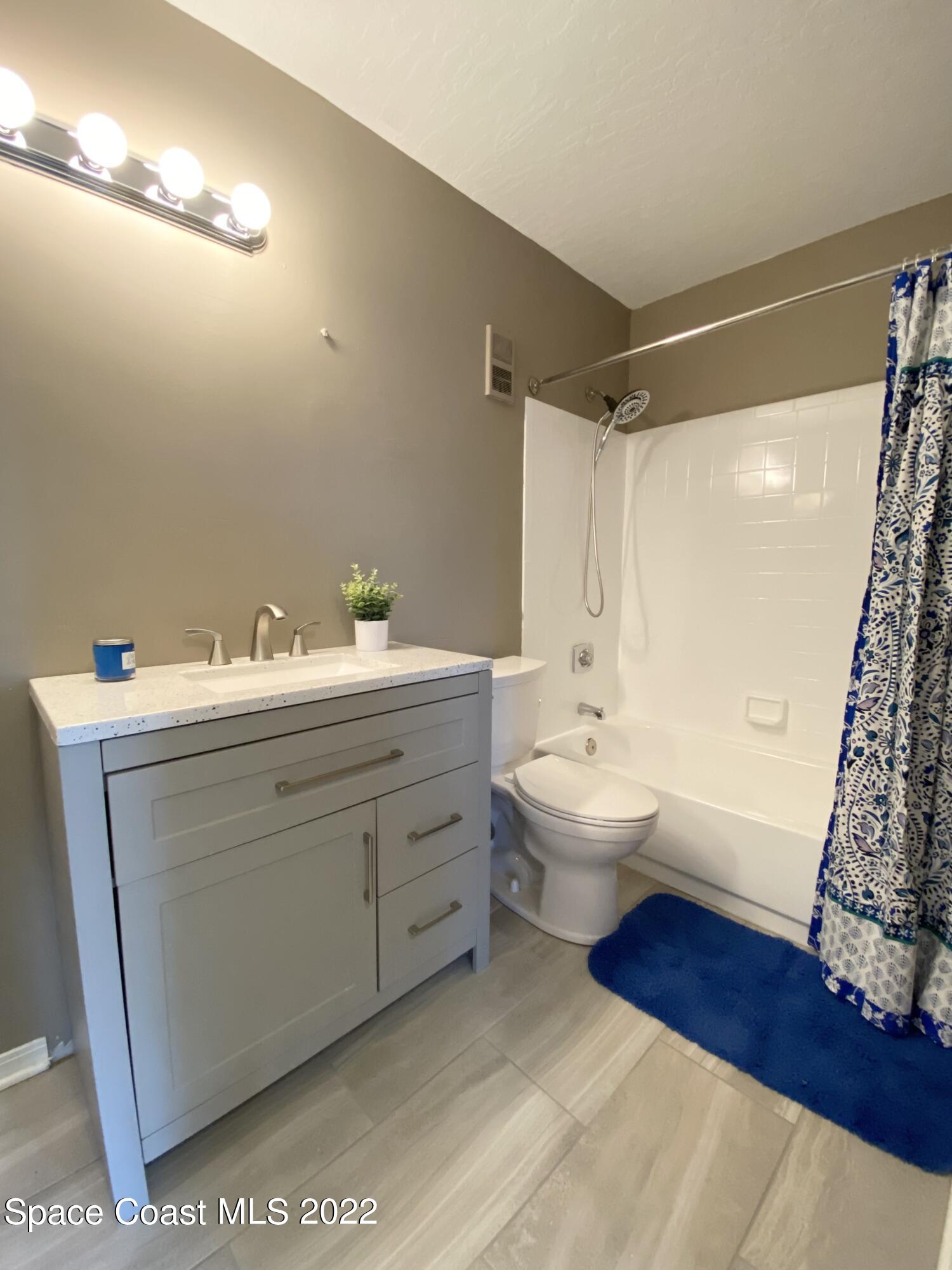 7667 North Wickham Road, Unit 418 Melbourne, FL 32940 - Photo 13 of 36 a bathroom with a double vanity sink mirror and toilet