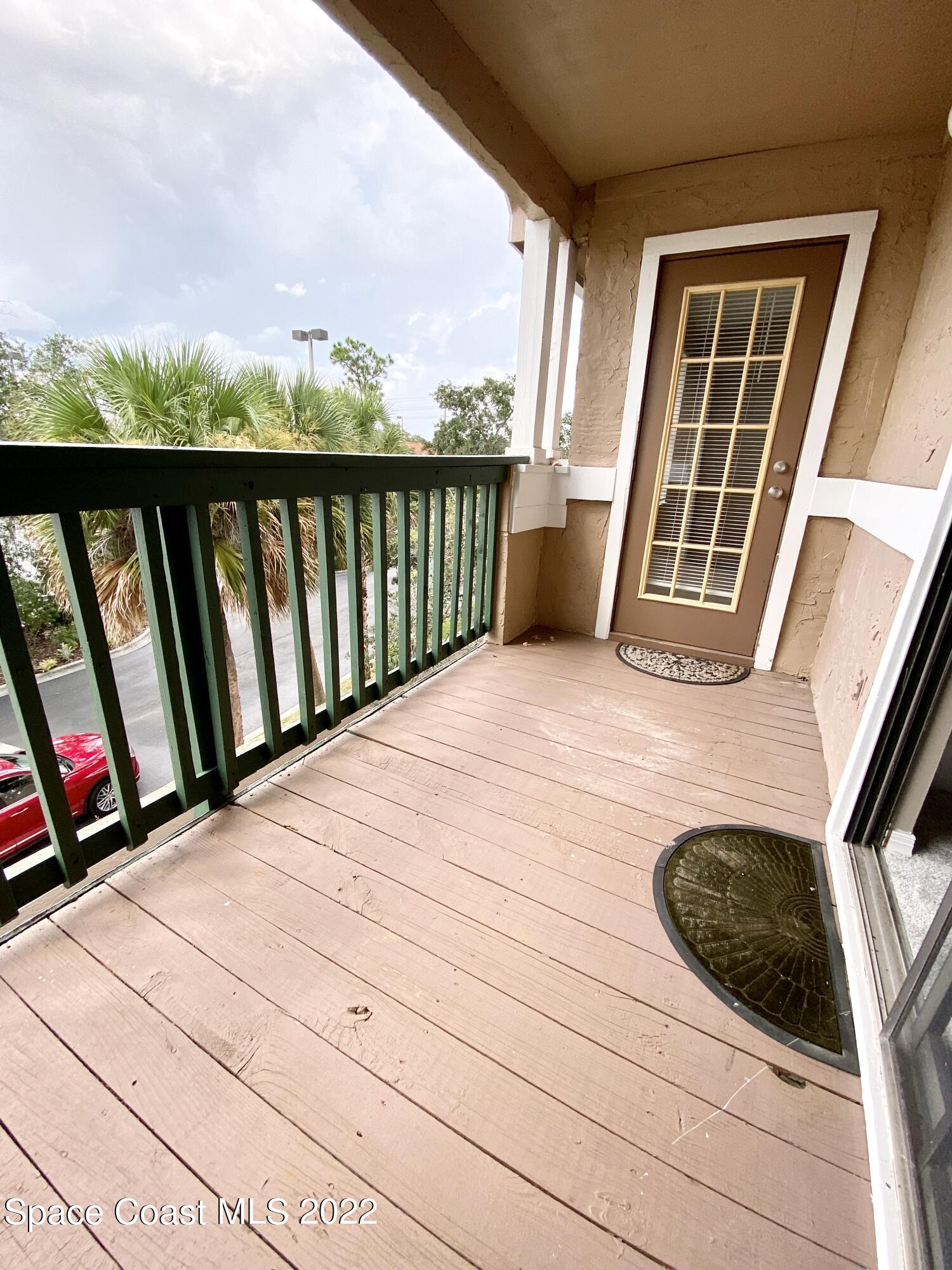 7667 North Wickham Road, Unit 418 Melbourne, FL 32940 - Photo 14 of 36 a view of balcony with wooden floor and fence