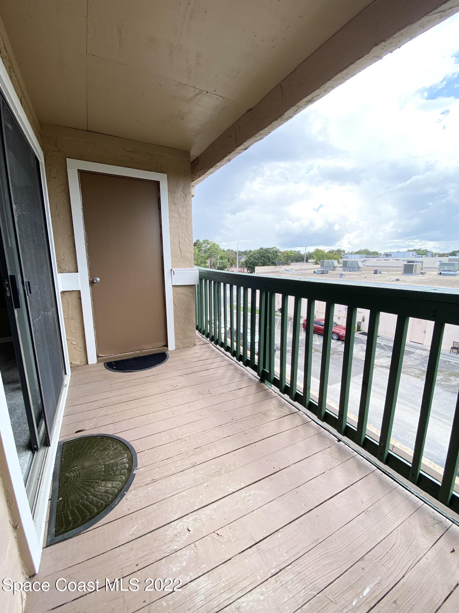 7667 North Wickham Road, Unit 418 Melbourne, FL 32940 - Photo 15 of 36 a view of balcony with wooden floor and fence