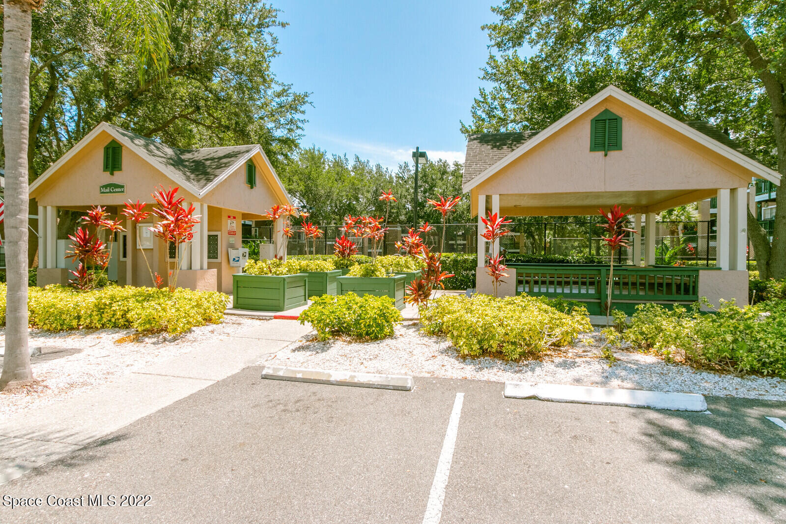 7667 North Wickham Road, Unit 418 Melbourne, FL 32940 - Photo 21 of 36 a front view of a house with a yard and potted plants