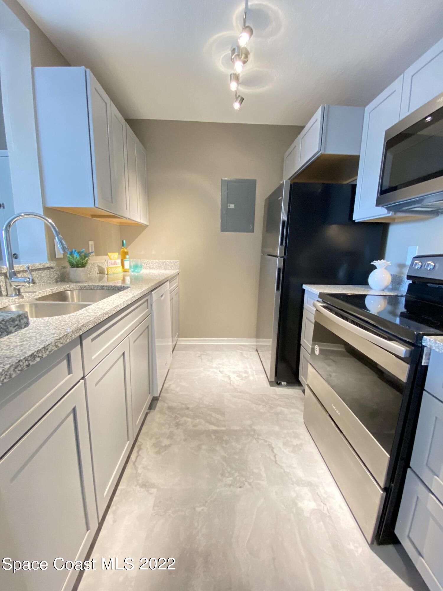7667 North Wickham Road, Unit 418 Melbourne, FL 32940 - Photo 9 of 36 a kitchen with a sink cabinets and appliances