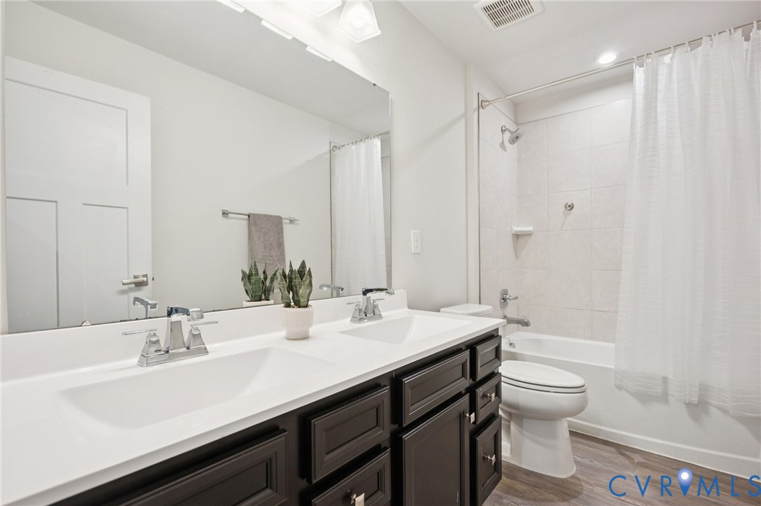 10237 Centralia Sta Road Chester, VA 23831 - Photo 26 of 35 a bathroom with a double vanity sink toilet mirror and shower