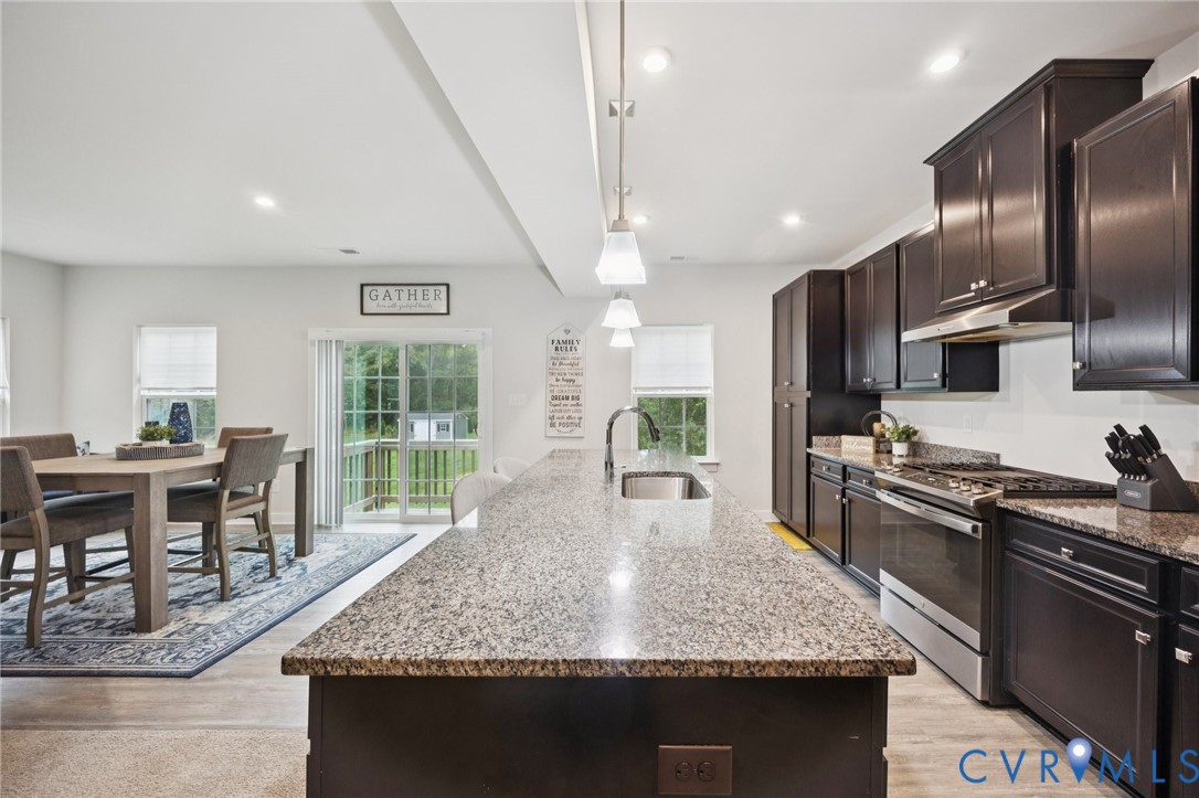 10237 Centralia Sta Road Chester, VA 23831 - Photo 5 of 35 a kitchen with stainless steel appliances granite countertop a stove top oven a sink dishwasher a dining table and chairs with wooden floor