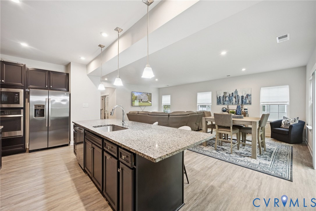 10237 Centralia Sta Road Chester, VA 23831 - Photo 7 of 35 a living room with stainless steel appliances kitchen island granite countertop a table chairs and a refrigerator