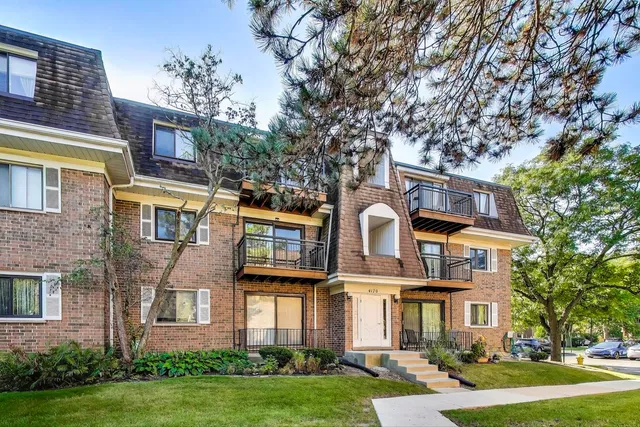 front view of a brick house with a yard