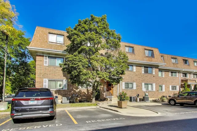 a front view of a building with a garden