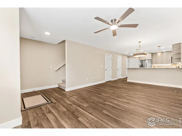 a view of empty room with wooden floor and ceiling fan