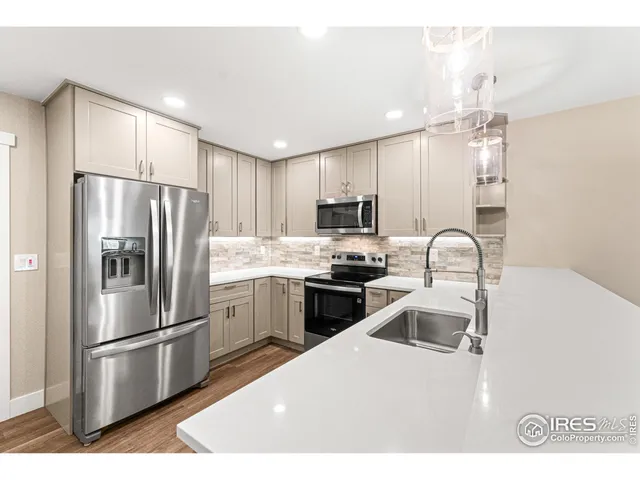 a kitchen with kitchen island a sink stainless steel appliances and cabinets