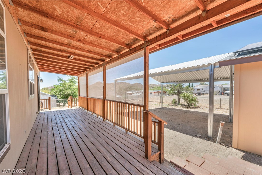 225 California Street Searchlight, NV 89046 - Photo 28 of 64 A spacious wooden deck with a shaded overhang offers a comfortable outdoor retreat.