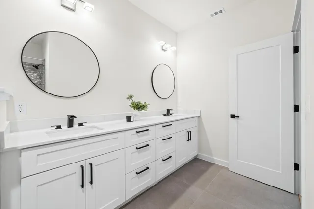 a bathroom with a double vanity sink and a mirror