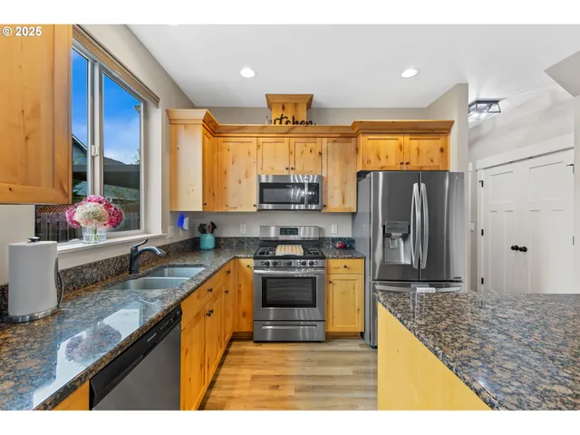 a kitchen with stainless steel appliances granite countertop a sink stove and refrigerator
