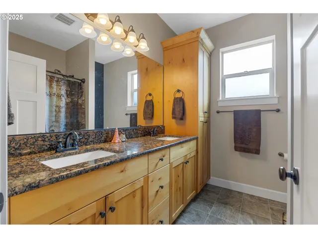 a bathroom with a double vanity sink and a mirror