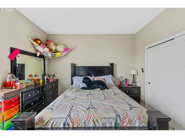 a bedroom with a bed purple white bedspread and pillows