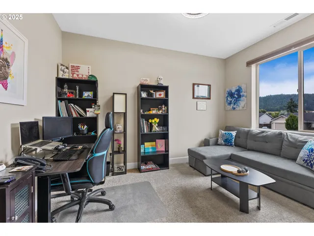 a living room with furniture a desk and a bookshelf