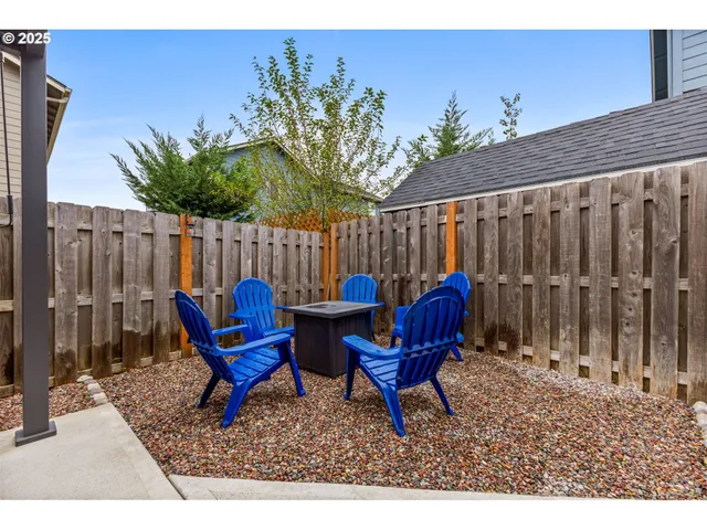 a backyard of a house with table and chairs