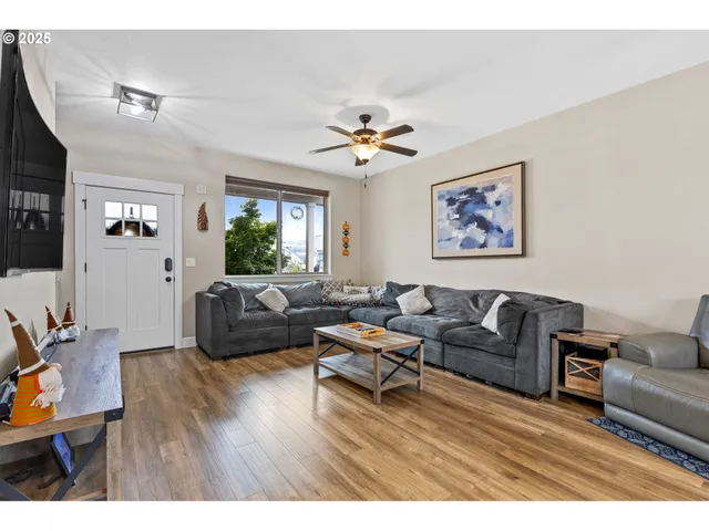 a living room with furniture a ceiling fan and a window