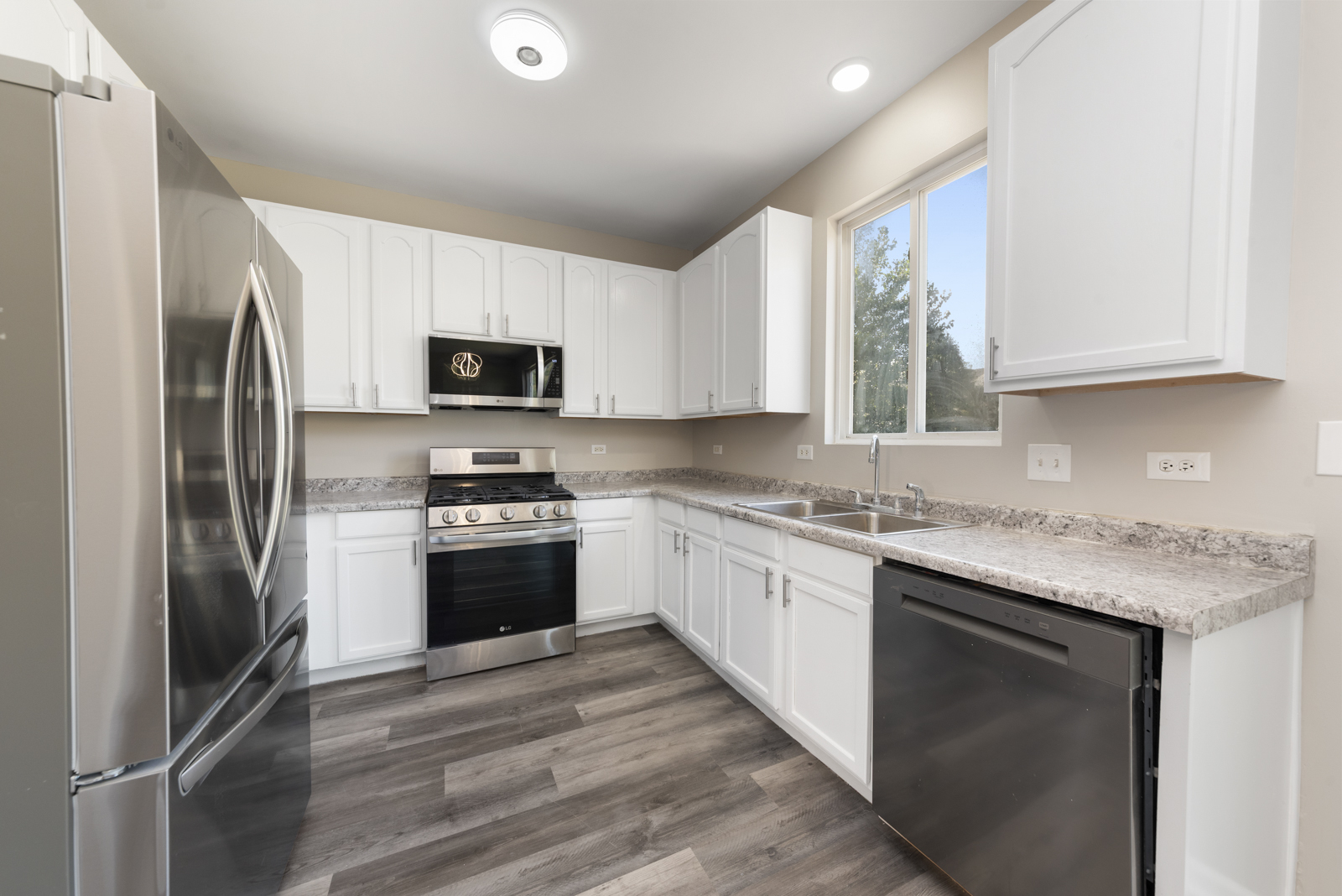 6407 Coyote Ridge Court Plainfield, IL 60586 - Photo 2 of 24 a kitchen with stainless steel appliances granite countertop a stove top oven a sink and a refrigerator
