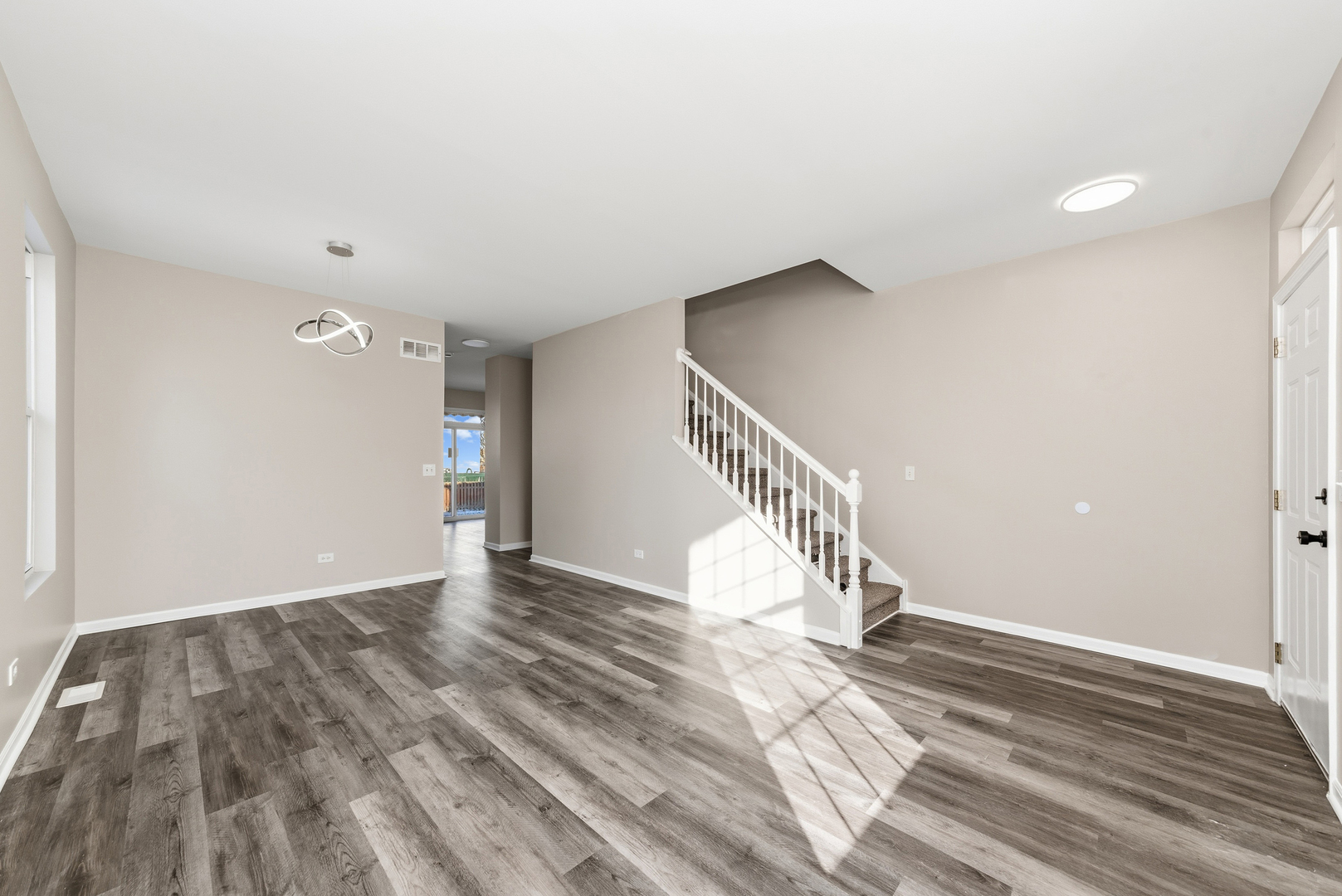 6407 Coyote Ridge Court Plainfield, IL 60586 - Photo 4 of 24 a view of an empty room with wooden floor and stairs