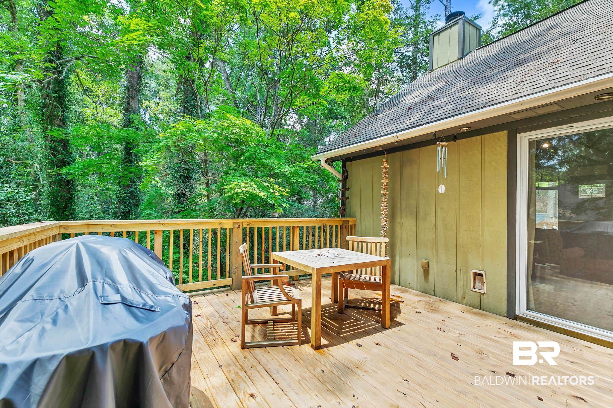 332 Ridgewood Drive Daphne, AL 36526 - Photo 28 of 48 Wooden terrace with a grill, outdoor dining area, and view of scattered trees