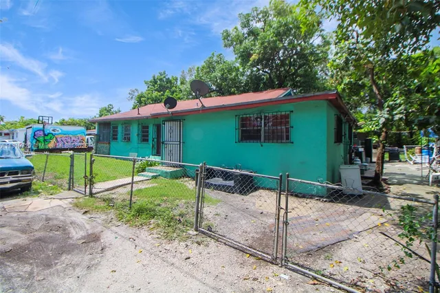 a view of a house with a backyard and a tree