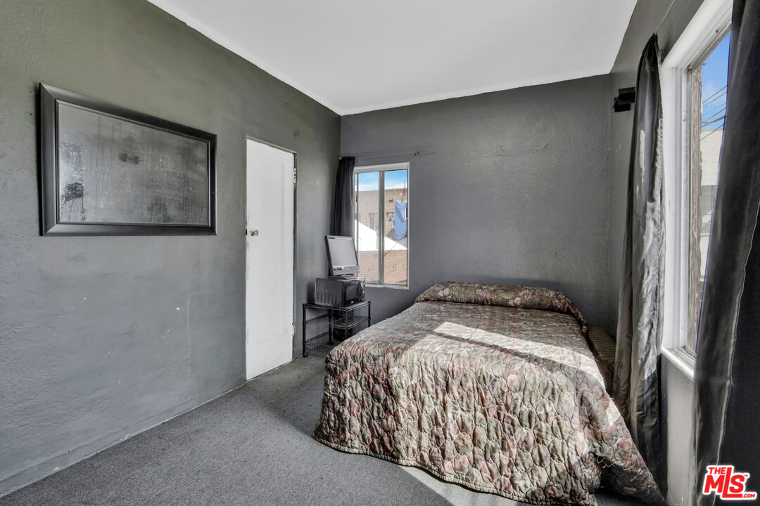 1042 Wilcox Avenue Los Angeles, CA 90038 - Photo 7 of 24 a bedroom with a bed and a painting on the wall