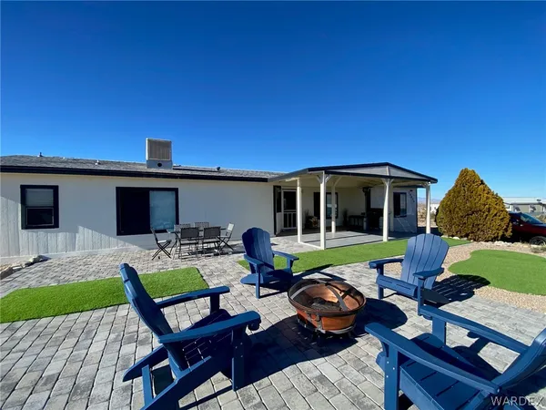 a view of a house with backyard sitting area and furniture